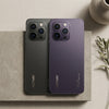 Two HOTWAV smartphones shown from the back, one in dark gray and one in deep purple, placed on a textured stone slab with a neutral beige background and decorative props.