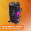 A tall, vertical, portable JBL PartyBox 710 speaker with colorful illuminated light patterns on the front. The speaker appears to be black with a handle on top and robust wheels at the bottom for mobility.
